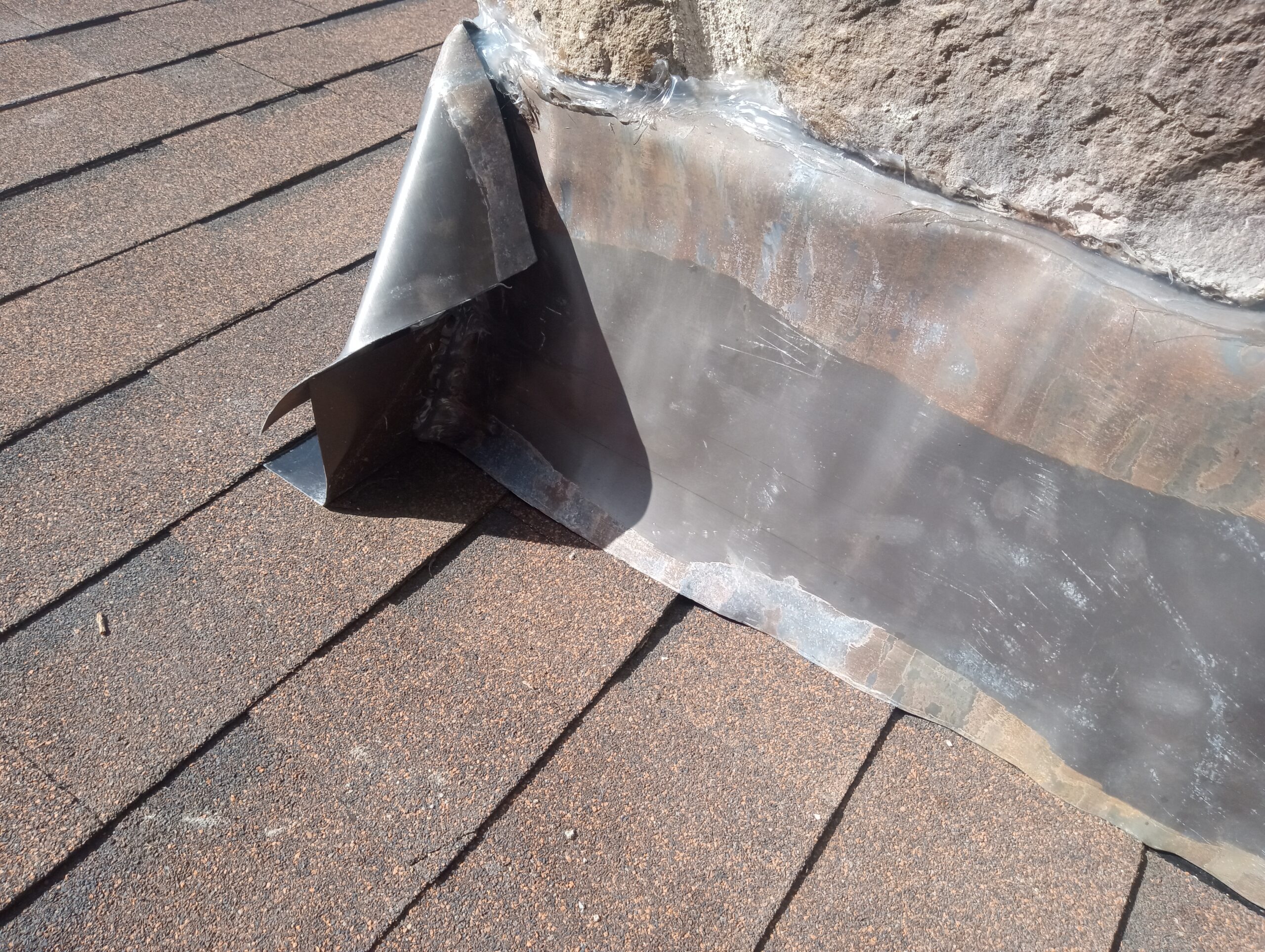 Front chimney flashing intersecting with side flashing.